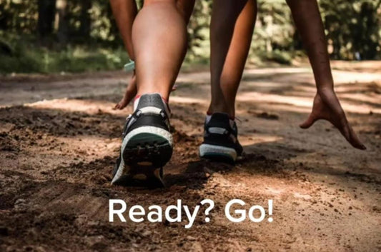 Fitness enthusiast in athletic gear poised at the starting line, ready to sprint, embodying the 'ready, set, go' pose in nature..